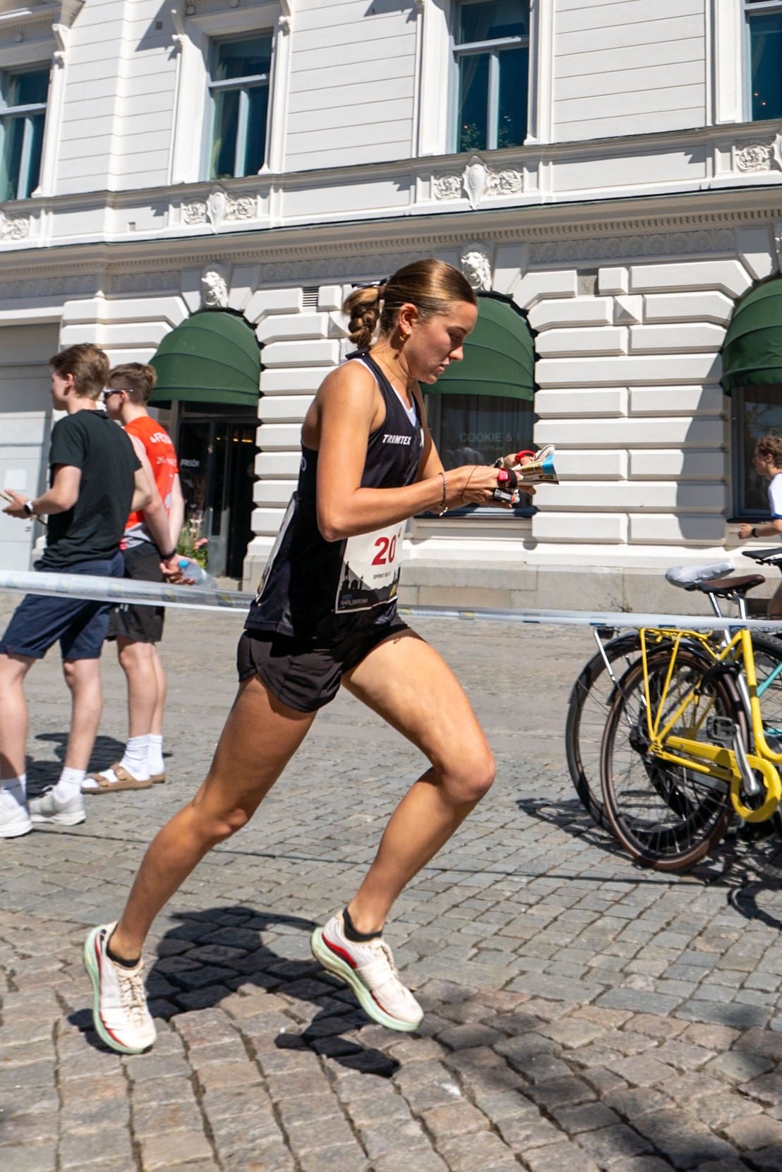 Zara Toes racing a sprint course on European cobbles, map in hand