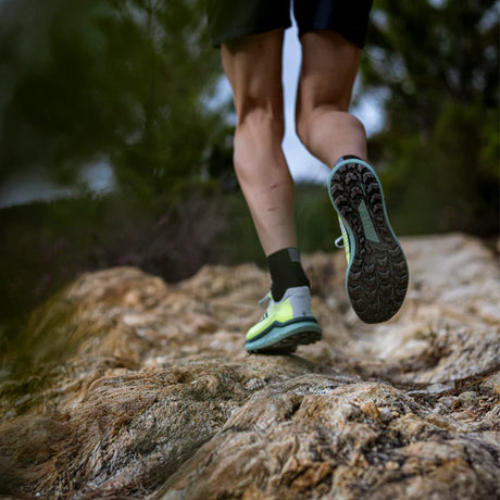 Runner wearing MAXx2 trail shoes with amazing grip on rocky terrain for a lightweight experience.