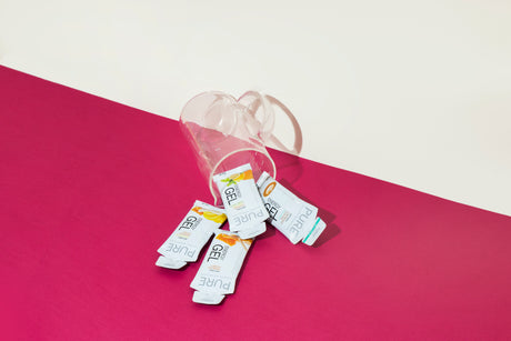 Product photo on pink and white background showing multiple gels spilling out of cup